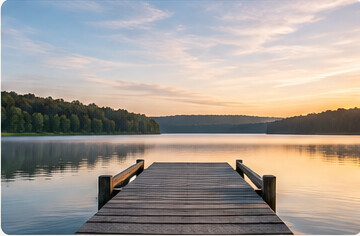 A quiet lake and wooden dock at sunset